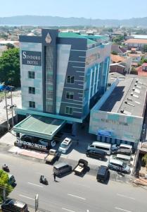 a building with cars parked in front of a street at Sindoro Hotel Cilacap By Conary in Cilacap