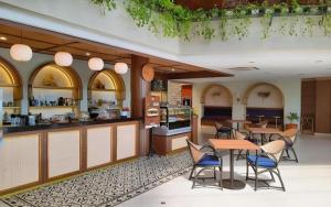 une cuisine et une salle à manger avec tables et chaises dans l'établissement Bentani Hotel & Residence, à Tangkil