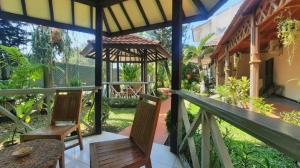 une terrasse couverte d'une maison avec deux chaises et une table dans l'établissement Bentani Hotel & Residence, à Tangkil