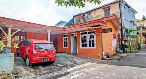 塔旺曼谷OYO 92759 Penginapan Piji Kembar的停在房子前面的一辆红色面包车 更多21张照片