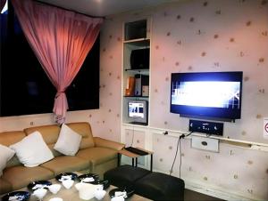 un salon avec un canapé et une télévision dans l'établissement Ayutthaya Grand Hotel, à Ban Han Tra Fang Nua