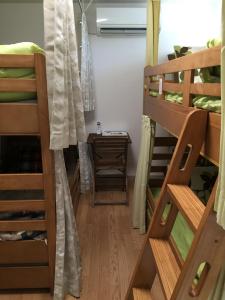 a room with three bunk beds and a table at Aun in Nagano