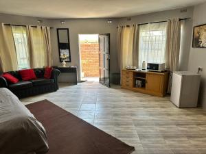 a living room with a bed and a couch at Staylax guesthouse in Harare