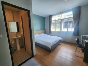 a bedroom with a bed and a window and a mirror at Wan Residence Ratchatewi in Bangkok