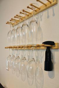 隠れ宿 藤 Private Inn Fuji - 足利駅5分の一棟貸切のお宿 في أشيكاغا: مجموعة من أكواب النبيذ معلقة على الرف