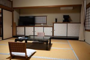 弘前市金剛山最勝院 寺泊的配有电视、桌子和椅子的房间