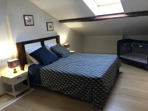 a bedroom with a bed with a blue and white comforter at La Fermette Aux Lamas in Savigny-Lévescault