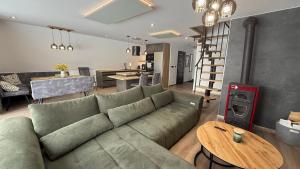 a living room with a green couch and a table at Luxusný CHALET DANIELS Tatranská Štrba in Štrba