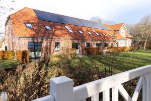 an old brick building with solar panels on it at Gulfhof Fresena in Norden