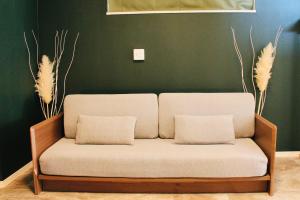 隠れ宿 藤 Private Inn Fuji - 足利駅5分の一棟貸切のお宿 في أشيكاغا: أريكة بيضاء مع وسادتين في غرفة المعيشة