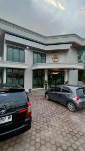 SolokにあるHotel Taufina Solokの建物の前に駐車した車両2台