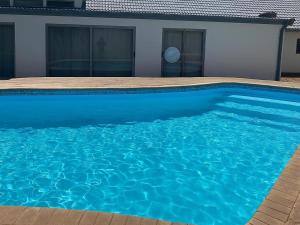 ein blauer Pool vor einem Haus in der Unterkunft Juliet Rose Luxury Guesthouse B&B in Bloemfontein
