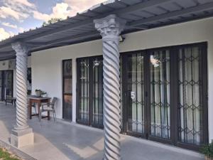 eine Pergola mit Säulen auf einer Terrasse in der Unterkunft Juliet Rose Luxury Guesthouse B&B in Bloemfontein