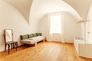 a living room with a couch and a window at Gewölbezimmer am Hauptplatz 28 in Retz +9 photos
