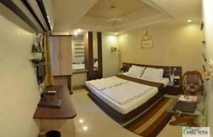 a bedroom with a bed and a table and a desk at Hotel Shree Vatika in Bhopal +21 photos