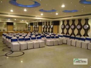 a banquet hall with blue and white chairs in it at Hotel Shree Vatika in Bhopal