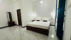 a bedroom with a bed with two pillows on it at The Secret Garden Sigiriya in Sigiriya +20 photos