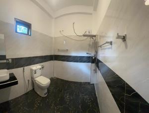 a bathroom with a toilet and a sink at The Secret Garden Sigiriya in Sigiriya