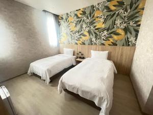 a room with two beds and a painting on the wall at 星雨行館-逢甲洲際館 in Taichung +12 photos