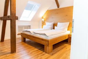 a bedroom with a bed with white sheets and pillows at Gulfhof Fresena in Norden