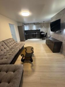 una sala de estar con un sofá y una mesa en Стильна, затишна, простора квартира в центрі, en Cherkasy
