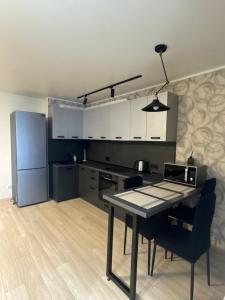Una cocina con una mesa y sillas en una habitación. en Стильна, затишна, простора квартира в центрі, en Cherkasy