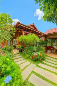 a garden in front of a house at Vườn Trà HomeStay Măng Đen in Kon Von Kla