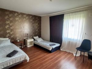 ein Schlafzimmer mit zwei Betten, einem Stuhl und einem Fenster in der Unterkunft Family & Worker Accommodations in Göteborg in Olofstorp