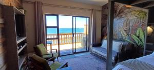 a bedroom with a view of the ocean from a balcony at Mitford Marula in Morganʼs Bay