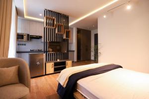 Un dormitorio con una cama y una silla y una cocina. en The Holton Stays by Bayti, en Rawalpindi