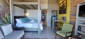 a bedroom with a bed and a table and a chair at Mitford Marula in Morganʼs Bay