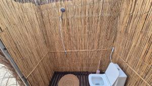 Al QārinOcean Camp的一间小浴室，厕所嵌在竹墙上。 更多41张照片