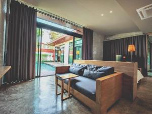 Sunday Sea Two Pool Villa Pattaya في جومتين بيتش: غرفة معيشة مع أريكة وطاولة