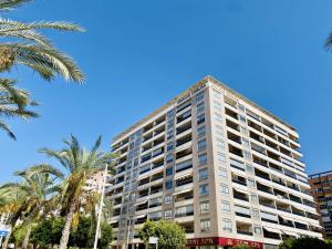 een hoog gebouw met palmbomen ervoor bij A908 - Coruna - 2004 Finestrat sl in Cala de Finestrat