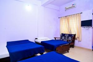 Postel nebo postele na pokoji v ubytování New Kanyakumari Lodge