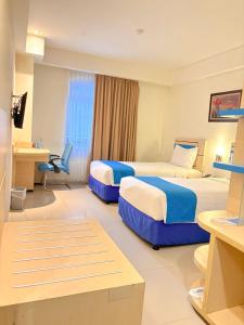 una habitación de hotel con dos camas y un escritorio en Hotel Brothers Solo, en Solo