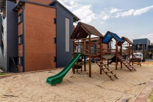 a playground with a green slide in the sand at The Waterfall Nest 3 CB in Midrand