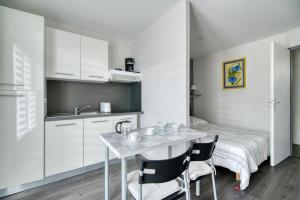 une cuisine avec une table et des chaises dans une pièce dans l'établissement Studio Le Laurier, à Lherm