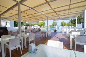 a restaurant with white tables and white chairs at SOLANA By YELKEN in Turgutreis