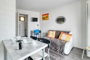un salon avec une table et un canapé dans l'établissement Studio Le Laurier, à Lherm