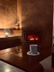 a coffee cup sitting on a table with a fireplace at Koliba 222 in Bratislava