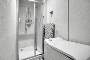 une salle de bain blanche avec une douche et un lavabo dans l'établissement Studio Le Laurier, à Lherm 13 autres photos