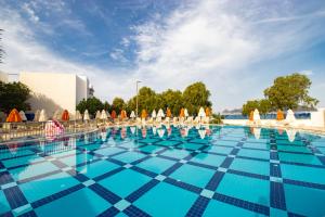 a large swimming pool with chairs and umbrellas at SOLANA By YELKEN in Turgutreis
