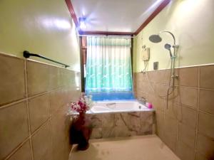een badkamer met een douche en een bad met een raam bij Family view A2 in Ko Bu Bu