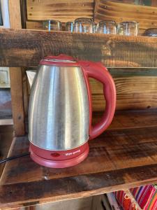 a red tea kettle sitting on a wooden shelf at Peaceful refuge homestay in Ninh Binh