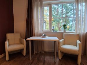 Ein Tisch und zwei Stühle vor einem Fenster in der Unterkunft Villa Bergstein in Tuk
