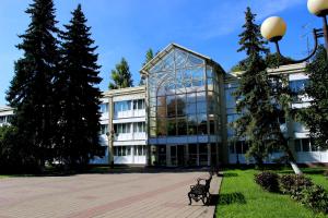 un gran edificio de cristal con un banco delante en Sanatoriy Valuevo, en Valuyevo