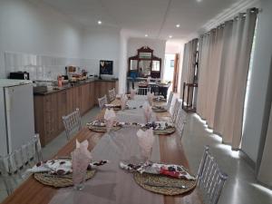 ein Esszimmer mit einem Tisch und Stühlen sowie eine Küche in der Unterkunft Juliet Rose Luxury Guesthouse B&B in Bloemfontein