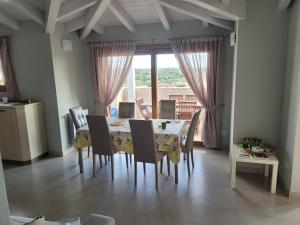 Un comedor con mesa y sillas y una ventana. en H41 Attico in centro, en Budoni