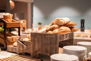 una cesta de pan en una mesa con platos en ProfilHotels Grand Kristianstad, en Kristianstad